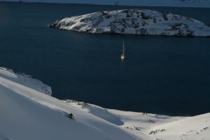 Nat Segal skiing perfect powder in West Greenland, with the La Louise sailboat below.